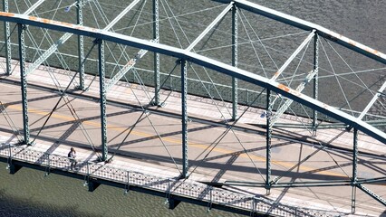 Walking outdoors for exercise while crossing a bridge over River in Binghamton City in New York State