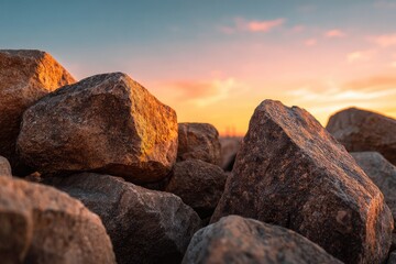 Close-up of large, textured rocks at sunset, warm hues in sky