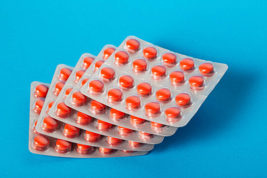 Red pills in blisters on a blue background. Concept sexual modulator for men, Viagra, close-up