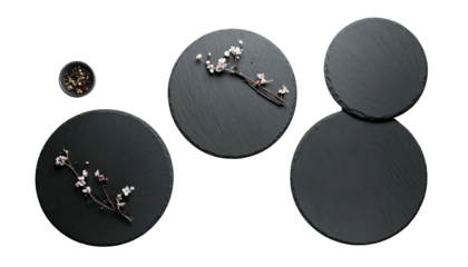 Overhead shot of dark gray circular platters, with sprigs and small bowl, isolated on black