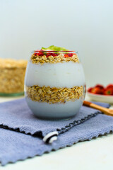 Delicious layered yogurt parfait featuring creamy white yogurt, crunchy toasted oats, and vibrant mixed fruit toppings served in a clear glass