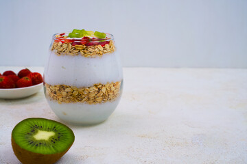 A refreshing layered yogurt parfait featuring creamy yogurt, toasted oats, fresh strawberries, and vibrant kiwi, perfect for a healthy start.