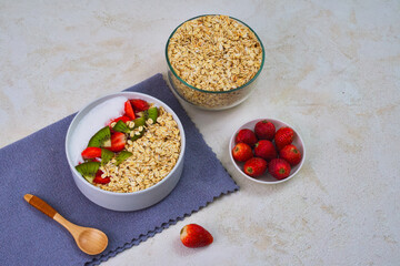 Delicious bowl of healthy oatmeal topped with fresh kiwi slices and vibrant strawberries, ready for a nutritious morning meal