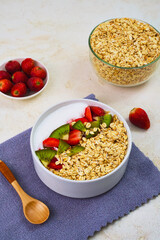 Wholesome bowl of oatmeal topped with fresh, vibrant kiwi slices and bright red strawberries, ready for a healthy breakfast or nutritious snack.