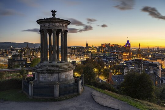 View from Calton Hill with the Dugald Stewart Monument over the historic Old Town with Edinburgh Castle at night, dusk, Edinburgh, Scotland, United Kingdom