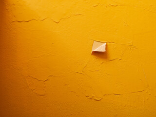 Minimal abstract background of a textured yellow wall with peeling paint and subtle imperfections, conveying decay, renovation, creativity, and bold color for modern design concepts.