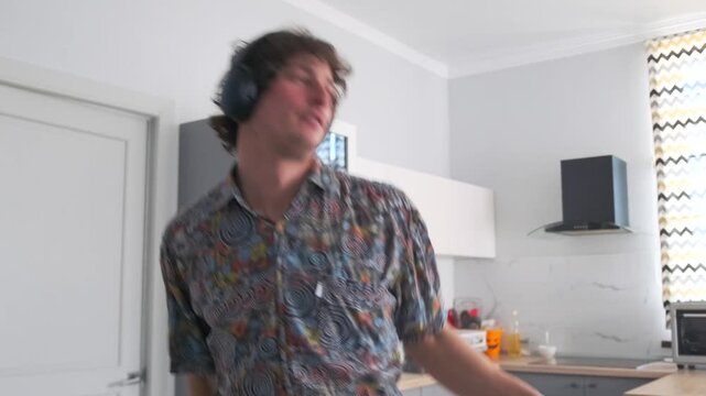 A young man in a shirt and headphones sings along to his favorite trac
