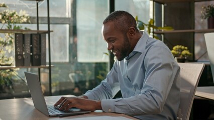 African American 40s business man typing laptop web service cyberspace adult businessman working online at office smiling mature male executive worker manager developer with computer data programming