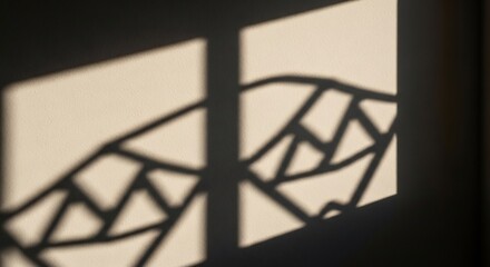 Sunlight casts geometric shadows of a decorative railing on a textured lighttoned wall