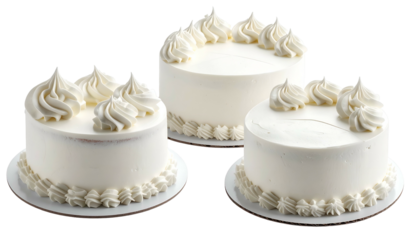 Three round frosted cakes on white platters.  Whipped cream swirls decorate the tops