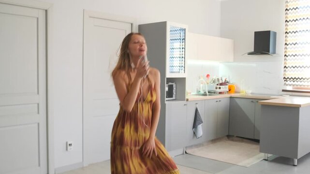 A young woman in a sundress sings and dances passionately in the kitch