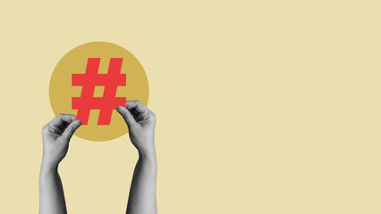 Grayscale hand holding a red hashtag symbol against a yellow circular background. Collage art. Concepts related to social media, technology, and trending topics
