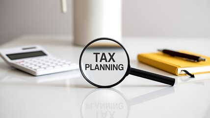 A magnifying glass with the words TAX PLANNING centered on a bright white desk