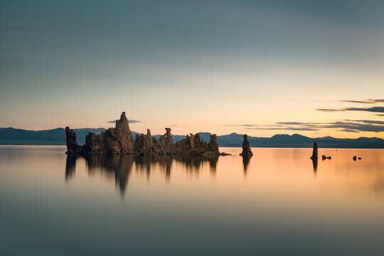 Sunrise at Mono Lake with its typical tufa towers reflecting on a calm water surface, California, USA