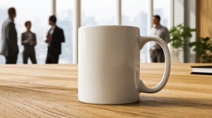 White coffee mug sits on a wooden table in front of a group of people. The mug is empty