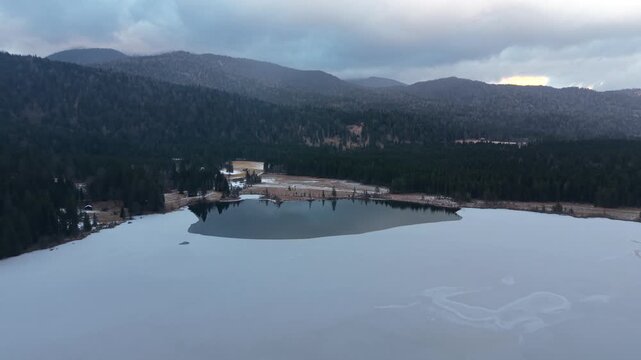 Drone panorama above Lake Barmsee in Bavarian Alps. Winter landscape with icy lake surface and mountain backdrop filmed from above. Cinematic drone footage of frozen Barmsee and Karwendel mountains