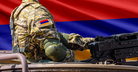 Fototapeta premium Armenia flag with soldier at machine gun turret in front of it. Closeup side view.