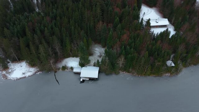 Cinematic drone footage of Barmsee in Oberbayern, Germany. Winter aerial view highlights frozen lake, forest and alpine mountains. Landkreis Garmisch-Partenkirchen. Winterliche Luftansicht