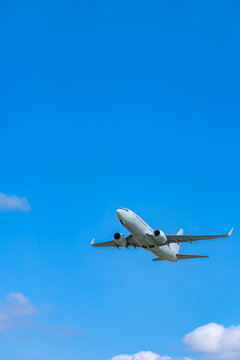 White passenger airplane taking off against blue sky