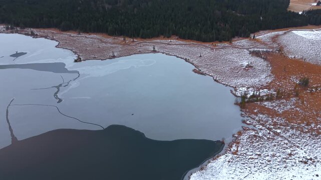 Luftbild des Barmsees in Oberbayern, Deutschland. Winterlicher Drohnenflug zeigt gefrorenen Bergsee, umliegende Waelder und Karwendel Gebirge. Cinematic drone footage of Barmsee. Karwendel mountains 