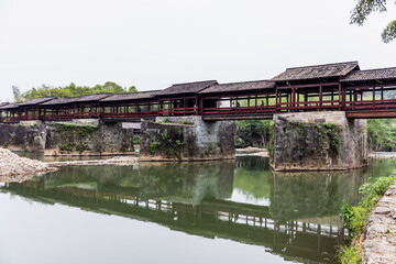 Obraz premium Ancient Covered Bridge in Wuyuan, China - Traditional Architecture Over River