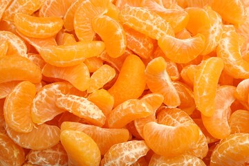 Many ripe peeled tangerines as background, top view