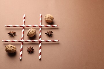 Tic tac toe game made with walnuts and anise stars on beige background. Space for text