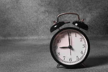 Close-up of a black vintage alarm clock on a gray background
