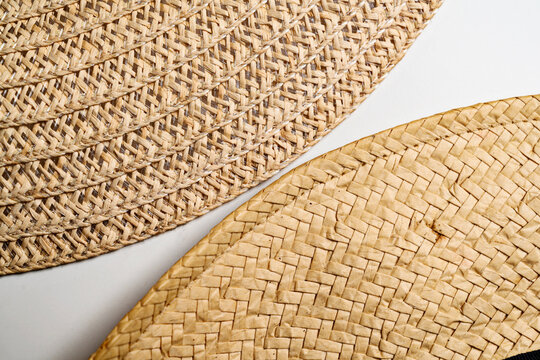 Closeup view of a woven fiber material, showcasing its intricate texture and construction on the edge of a white background - Powered by Adobe