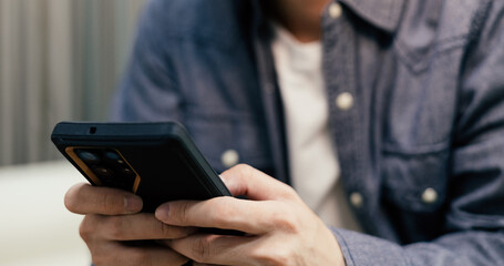 Close-up of hands using smartphone for social media, mobile banking, and online shopping. Professional man browsing internet, texting on cellphone. Concept of digital lifestyle and technology.