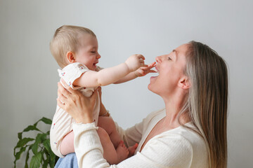 Mom and a baby playing and laughing together. Copy space, background.