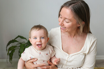 Mom and a baby playing and laughing together. Copy space, background.