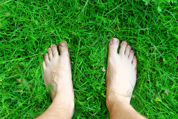 Carefree woman standing barefoot on fresh grass
