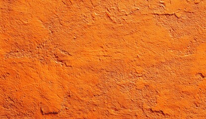 Textured close-up of a weathered orange surface, showing cracks and unevenness