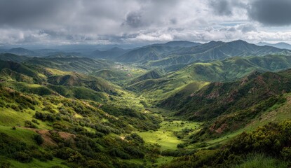 Fototapeta premium A panoramic view of rolling green hills and valleys under a cloudy sky