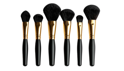 Array of makeup brushes with black bristles, gold ferrules, and black handles against dark