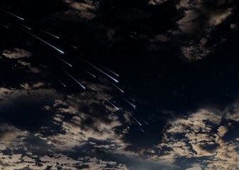 Meteor shower in the night sky. Shooting stars between the clouds. Fireballs in the atmosphere.
