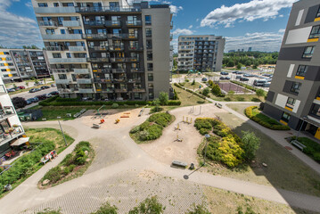 Modern Residential Home Buildings with Spacious Courtyards and Playgrounds on Sunny Day
