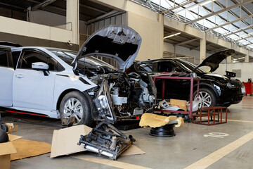 White car with dismantled front bumper during major repair in garage