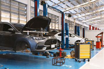 Car engine supported by a steel hanger bar during repair service