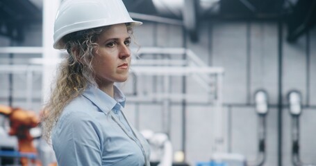 Manufacturing Engineer Walks Professionally Among Clean, Bright Structural Elements Factory. Woman White Hard Hat Mandatory Gear. On Site Engineering Expertise in High Quality Production Environment.