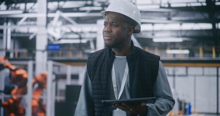 Critical Process Monitoring, Manager Analyzing Metrics on Handheld Device. Man in Safety Gear Walk Through Smart Factory With Concentrated Expression. Real Time Troubleshooting, Operational Intensity.