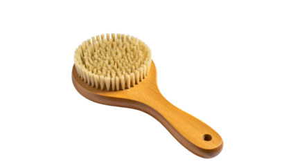 Round wooden handled body brush with natural bristles, isolated against a black backdrop