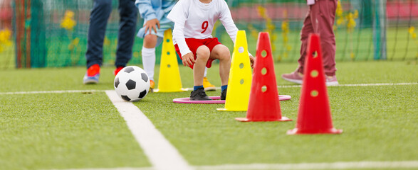 Youth Soccer Agility Drill With Cones. Kids Practicing Football Ball Control and Coordination on Field