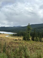 Calm natural setting featuring distant hills and pine trees
