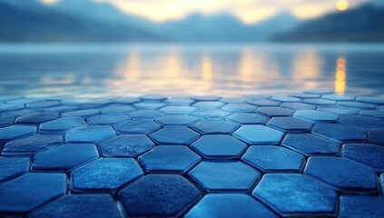 Futuristic blue hexagonal path leads to calm lake reflecting a vibrant sunset over a distant mountain range