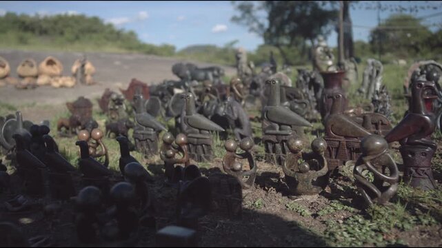 Slow motion slo mo outdoors and outside of small hand-crafted bird statues and sculptures with iconic soapstone carvings from Great Zimbabwe in an African culture representing royalty, spirituality