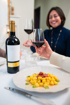 Italian gnocchi with red wine during cozy dinner with friends at home