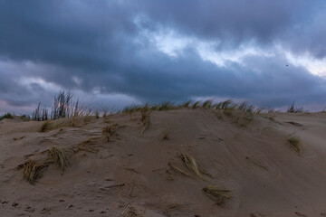 Dramatische K&uuml;stenlandschaft mit Sandd&uuml;nen und wechselhaftem Himmel