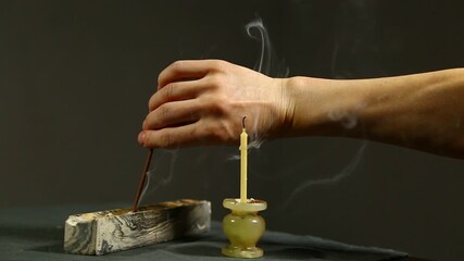 Woman hand extinguishing incense aroma stick 